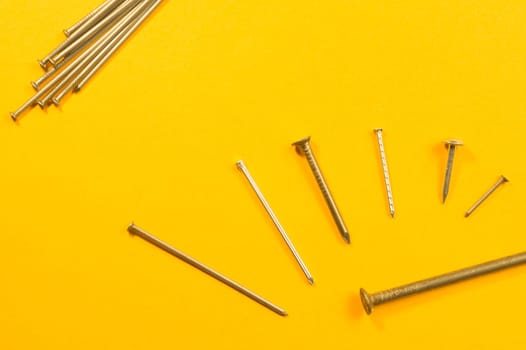 Metal nails isolated on yellow background