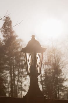 Retro street lamp at sunset. Vintage lantern at evening light background
