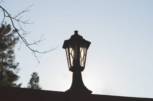 Retro street lamp at sunset. Vintage lantern silhouette. copy space