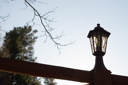 Retro street lamp at sunset. Vintage lantern at evening light background