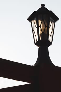 Retro street lamp at sunset. Vintage lantern silhouette. copy space