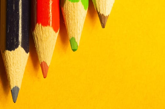 Colorful pencils isolated on yellow background. drawing supplies