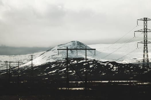 Mountain landscape background. snowy hills and forest. industrial power lines in mountains