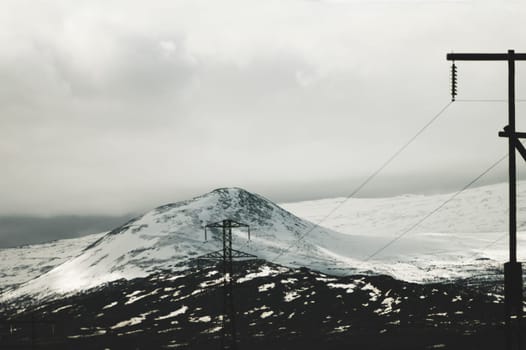 Mountain landscape background. snowy hills and forest. industrial power lines in mountains