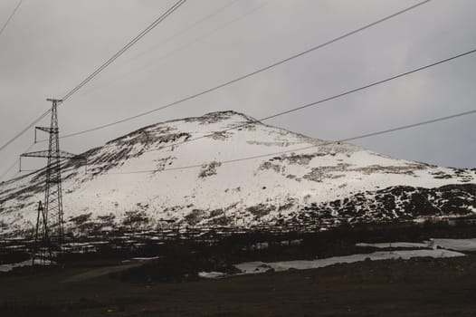 Mountain landscape background. snowy hills and forest. industrial power lines in mountains