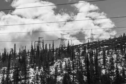 Mountain landscape background. snowy hills and forest. industrial power lines in mountains