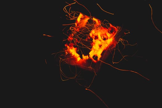 Fire flames with sparks in the dark background. bonfire at night