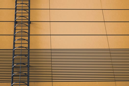 Brown wall of modern building with emergency ladder background