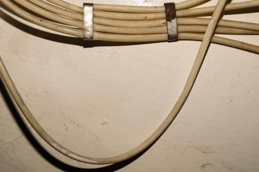 Old electrical wires or cables hanging on the wall. industrial background