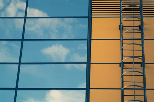 Glass wall of business center with sky reflection. modern building with large mirror window