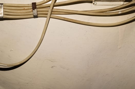 Old electrical wires or cables hanging on the wall. industrial background