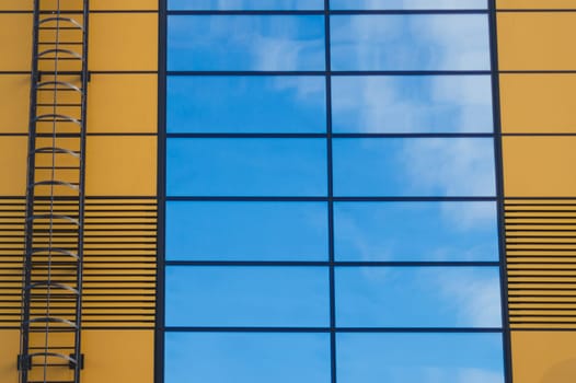 Glass wall of business center with sky reflection. modern building with large mirror window