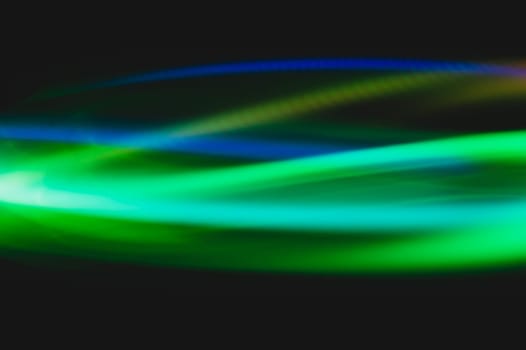 Colorful light traces with long exposure in the dark. abstract blurred lights background
