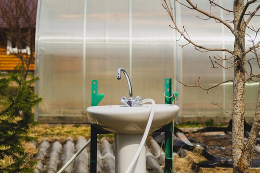 Sink and faucet in the garden. water tap outside the house. backyard of the summer house. closer to nature concept