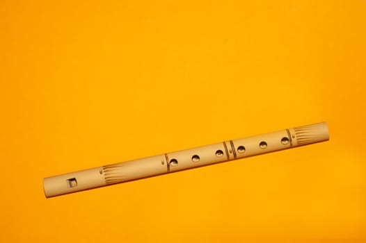 Bamboo flute. simple wind instrument. bansuri flute on yellow background