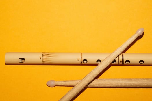 Bamboo bansuri flute and drumsticks. simple music instruments