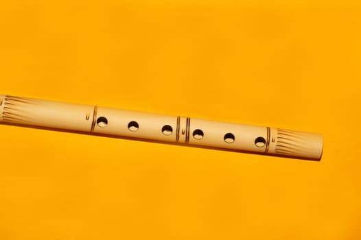 Bamboo flute. simple wind instrument. bansuri flute on yellow background