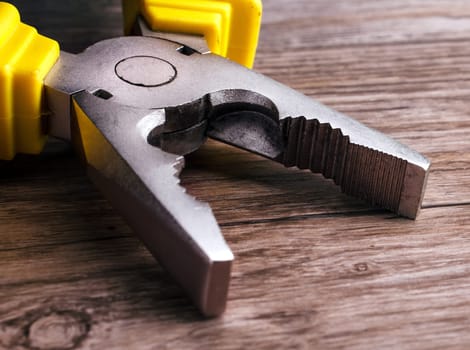 Close up of a multitool pliers on wooden background