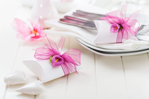 Decorated table in white with small present for the guests