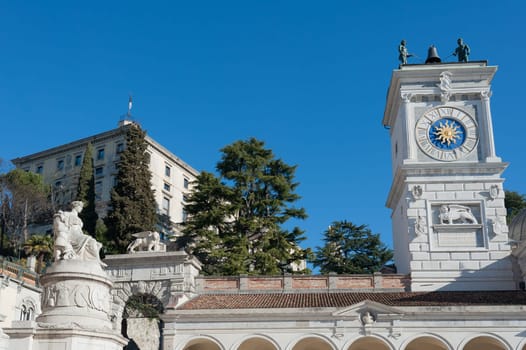 The statue of Peace with the clock tower of chiesa.In Freedom Square, Udine Italy