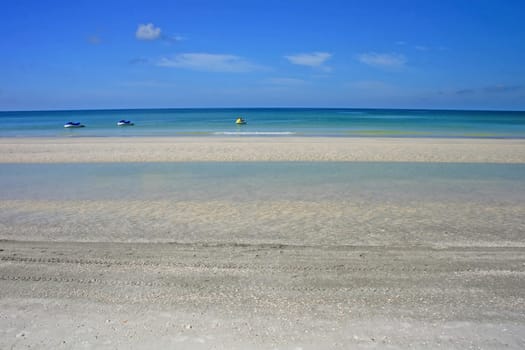 3 jet skis on the ocean near the beach