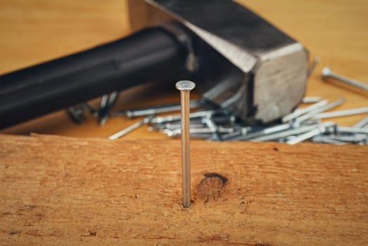Hammer and nails on wooden board