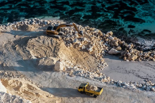 Construction process of the road next to the ocean. Calicium rock formation is used as a background for the future road.