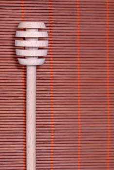 Wood Honey spoon on a nice wicker carpet as background