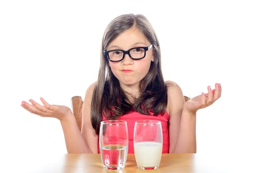 a little girl has a choice between a glass of water and a glass of milk