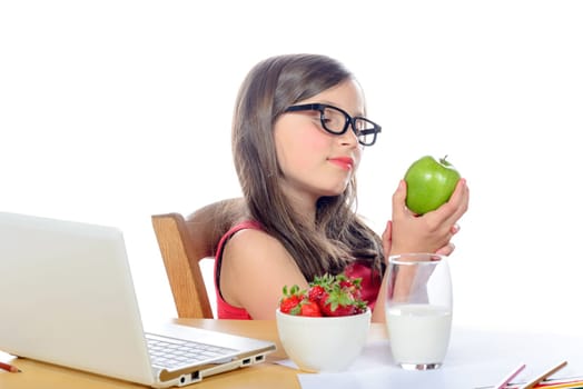 a little school girl looks apple on her desk