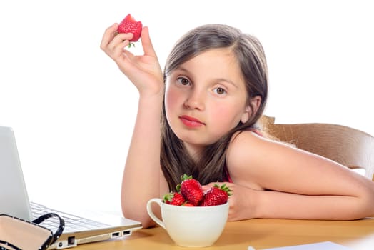 a little girl eating a strawberry to his desk