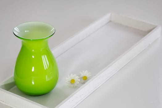 Green vase on a white tray