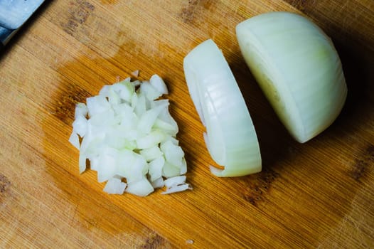 White onion on a wooden cutting board. vegetable slicing process. cooking food