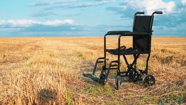 Empty wheelchair in a wide meadow. disabled carriage in nature. medical equipment for invalid person. horizon line dividing field and sky