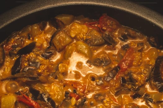 Stewed vegetables. ragout with eggplant and squash. cooking process of vegetarian food. ratatouille close up background