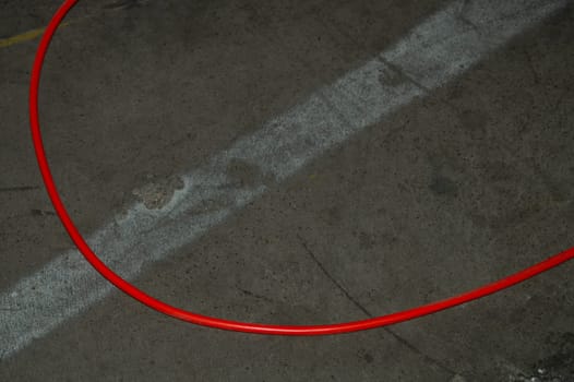Red electric power cable. red wire lies on the ground. mess on cement floor. industrial background