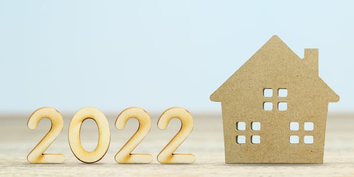 Wooden numeric new year 2022 house model on table with copy space