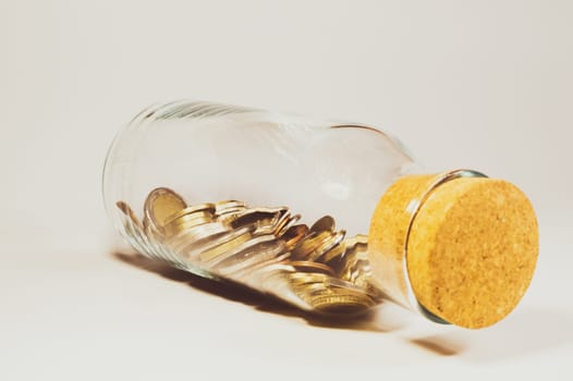 Glass jar with cork stopper and filled with international coins from various countries. transparent moneybox. finance storage concept