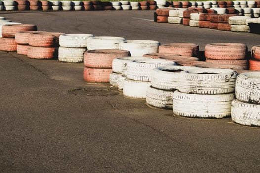 Race track safety barrier. asphalt racing track with red and white tires. colorful tires stack. karting race track