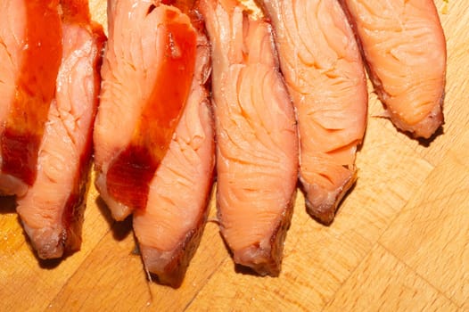 Red fish pieces close up. smoked salmon. seafood on a wooden table