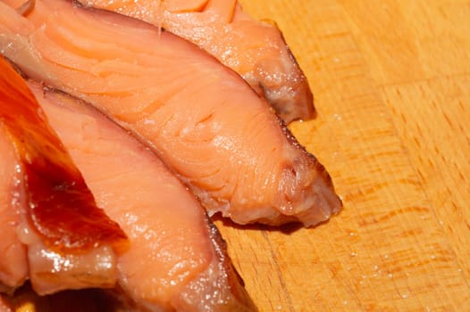 Red fish pieces close up. smoked salmon. seafood on a wooden table