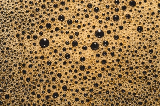 Coffee foam with bubbles macro texture. froth drink background