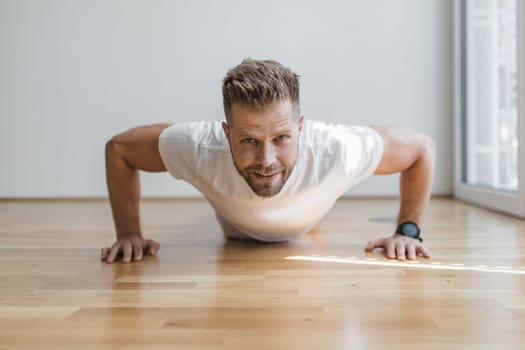 Handsome young man working out at home with a smart watch