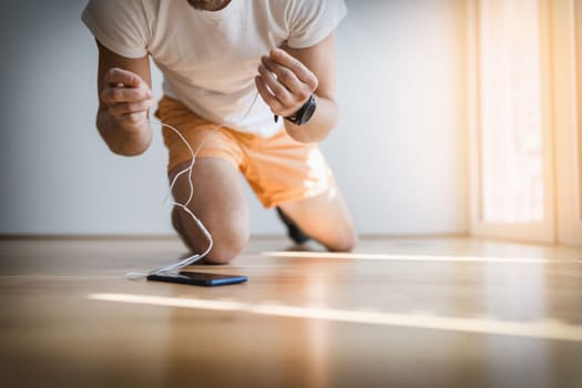 Handsome young man working out at home with a smart watch