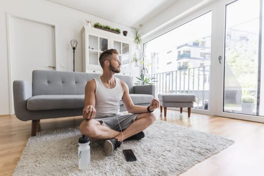 Handsome young man working out at home in the living room