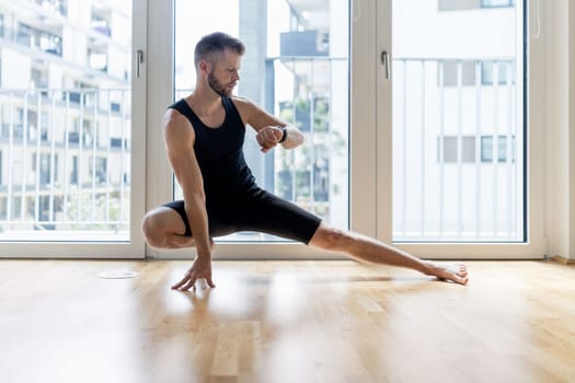 Young handsome man practicing yoga at home