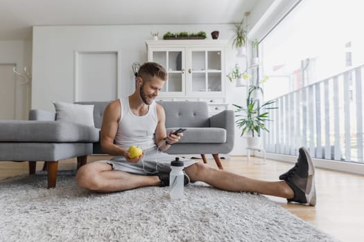 Handsome young man working out at home in the living room