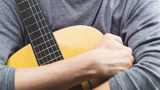 Man holds acoustic guitar. string instrument