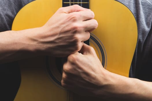 Man holds acoustic guitar. string instrument
