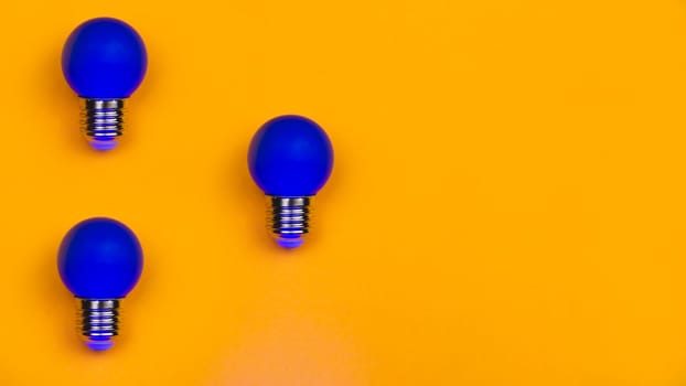 Blue light bulbs on a yellow background. several lightbulbs with copy space